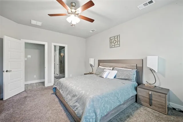 a bedroom with a large bed and a chandelier