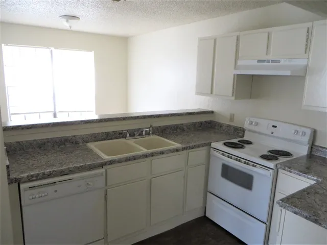 a view of a kitchen with cabinets appliances and a window