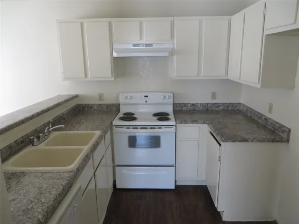a white kitchen with sink and granite