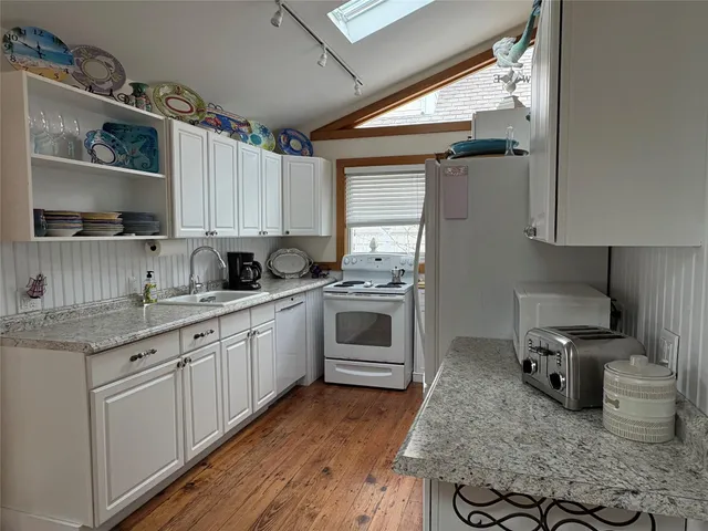 a kitchen with granite countertop a sink stainless steel appliances and cabinets