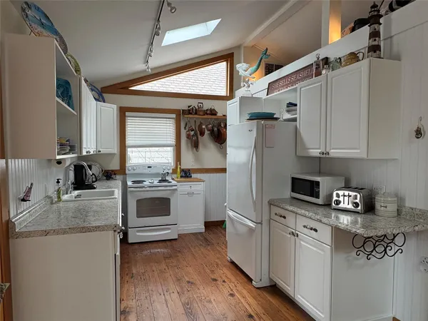 a kitchen with granite countertop a sink stainless steel appliances and cabinets