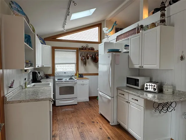 a kitchen with granite countertop a sink stainless steel appliances and cabinets