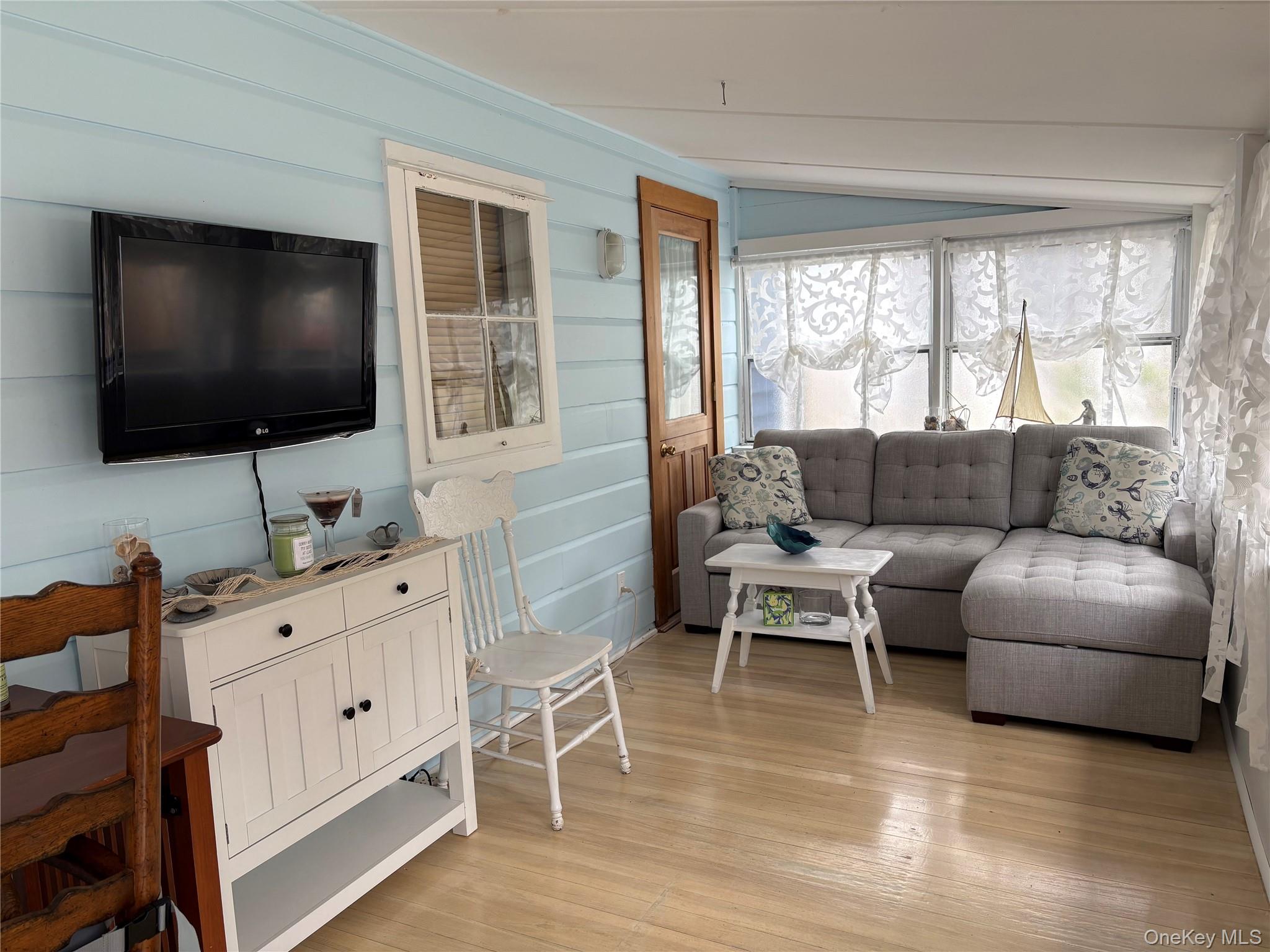 177 Wilmot Road Ocean Beach, NY 11770 - Photo 5 of 12 a living room with furniture and a flat screen tv