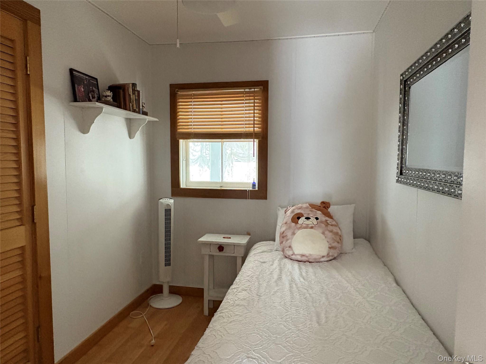 177 Wilmot Road Ocean Beach, NY 11770 - Photo 10 of 12 a bedroom with a bed and window