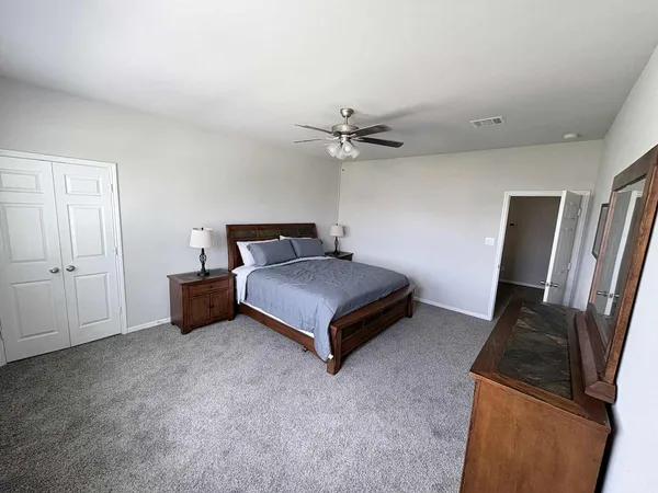 a bedroom with a bed and a flat tv screen on a dresser