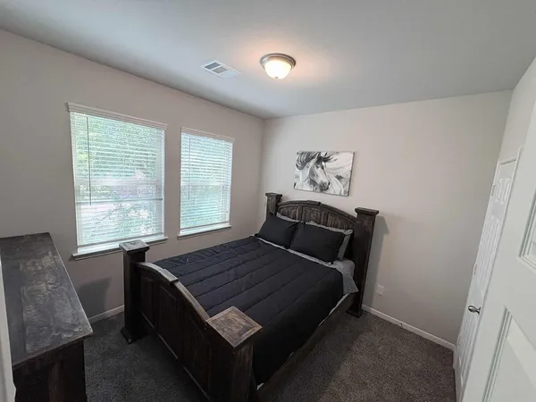 a bed sitting in a bedroom next to a window