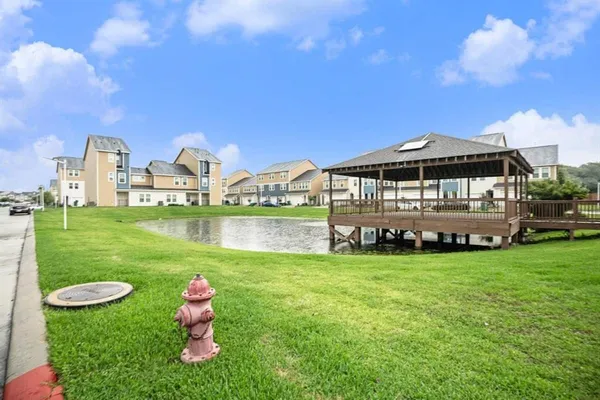 a view of a house with yard and a pond