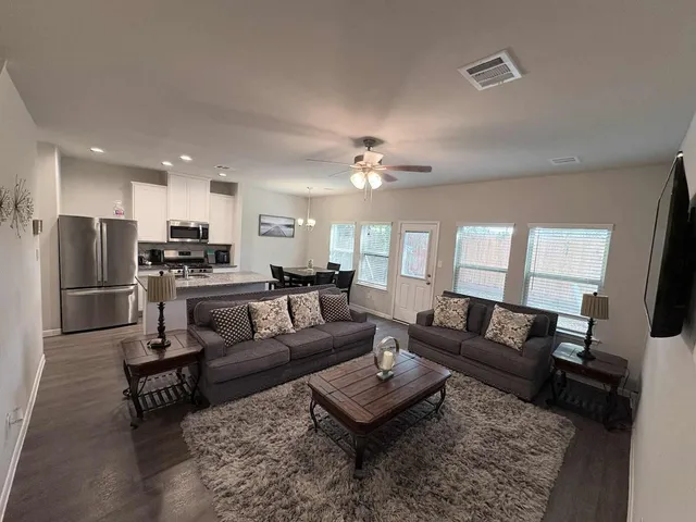 a living room with furniture and kitchen view