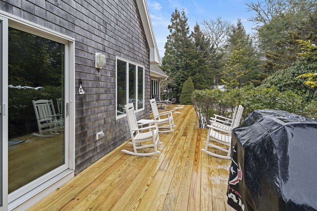 64 Jernegan Pond Road Edgartown, MA 02539 - Photo 21 of 25 a view of a patio with table and chairs with wooden floor and fence