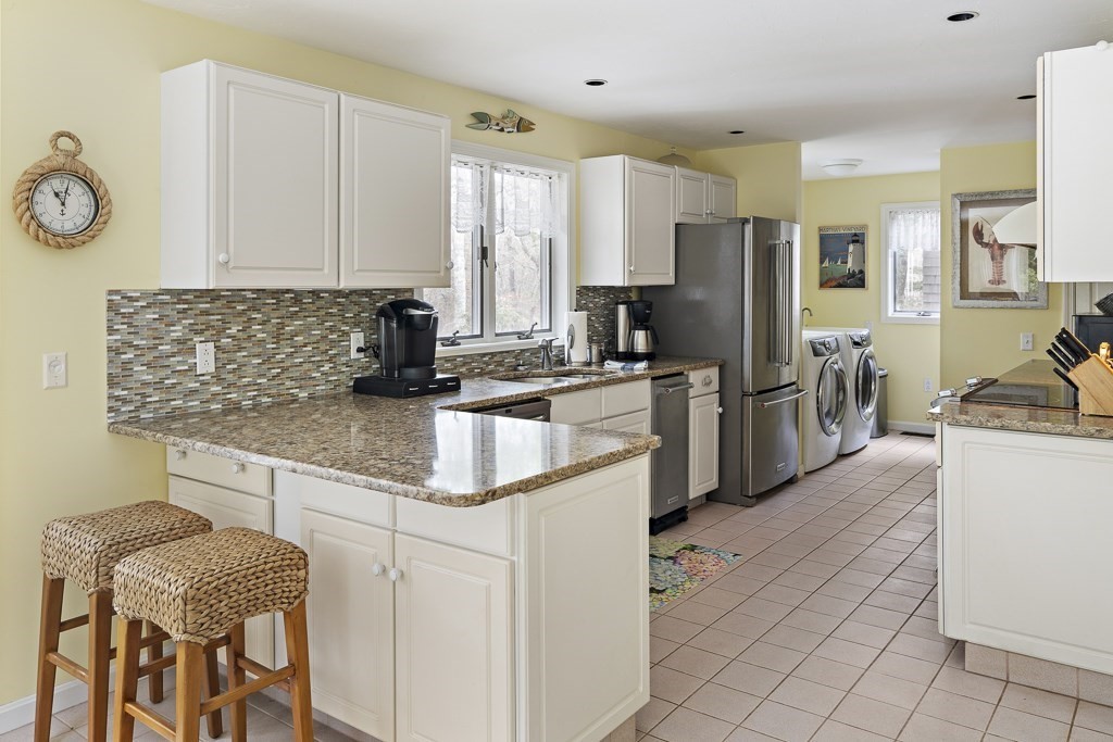 64 Jernegan Pond Road Edgartown, MA 02539 - Photo 8 of 25 a kitchen with a refrigerator a stove a sink and a cabinets