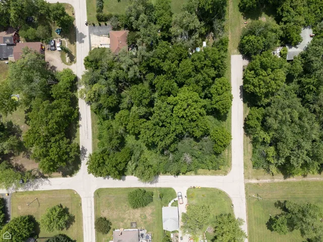an aerial view of residential house with outdoor space and trees all around