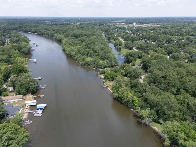 an aerial view of a house with a yard and lake view