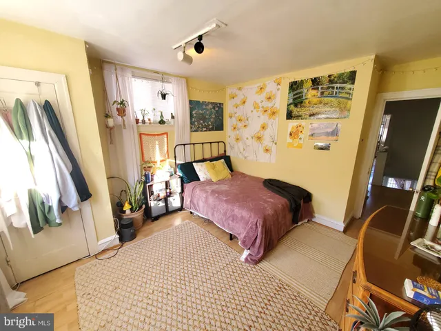a bedroom with a bed and a flat tv screen on the dresser