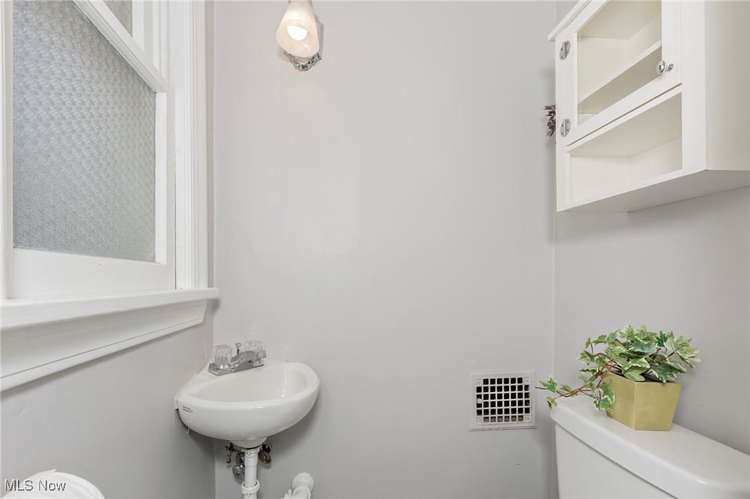 3826 Silsby Road Cleveland, OH 44118 - Photo 15 of 41 Half bathroom featuring toilet, a sink, and visible vents