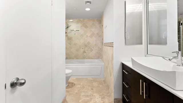 a bathroom with a granite countertop sink a toilet and shower