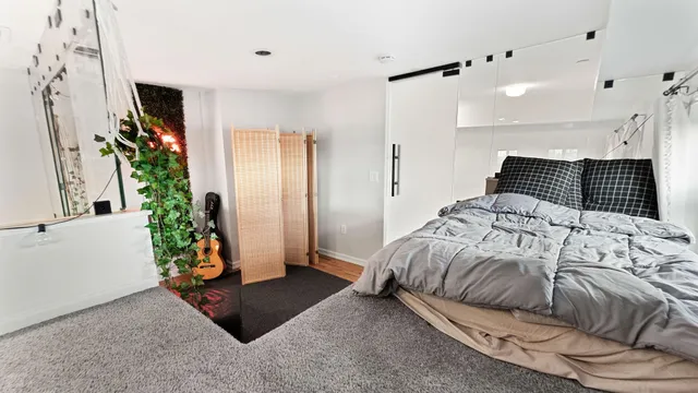 a spacious bedroom with a bed and a potted plant