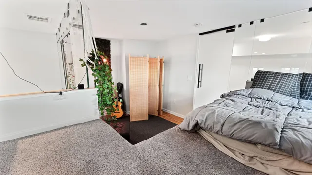 a bedroom with a bed and a potted plant