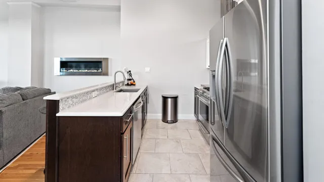 a kitchen with stainless steel appliances granite countertop a refrigerator and a sink