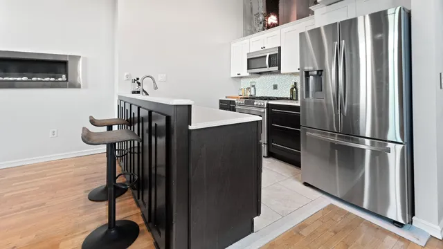 a kitchen with stainless steel appliances granite countertop a refrigerator and a stove top oven
