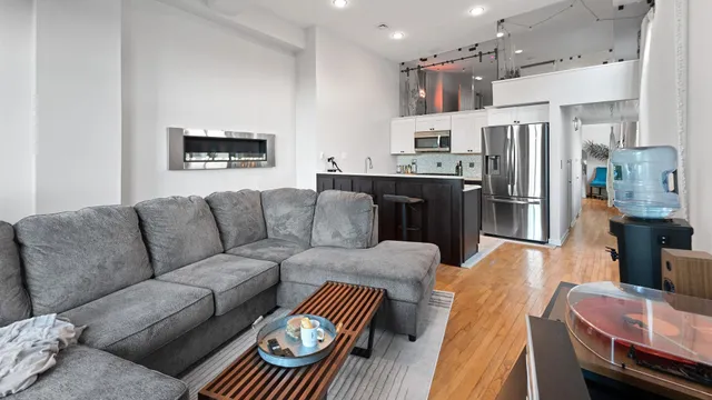 a living room with furniture and a refrigerator