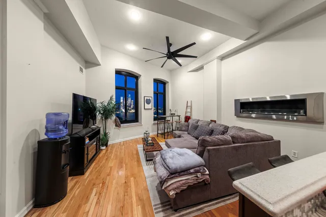 a living room with furniture a flat screen tv and a fireplace
