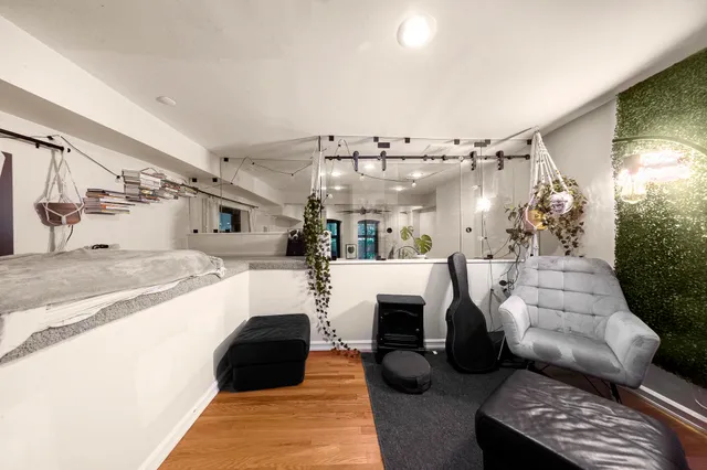 a living room with stainless steel appliances furniture a couch and a kitchen view