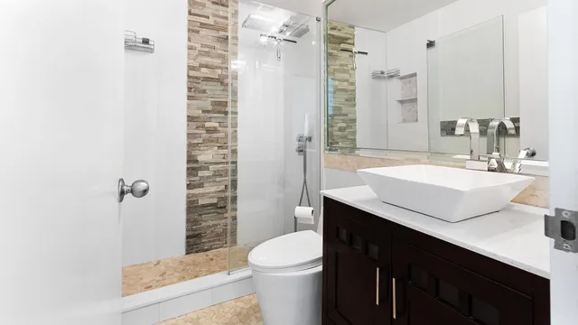 a bathroom with a sink a toilet a mirror and shower