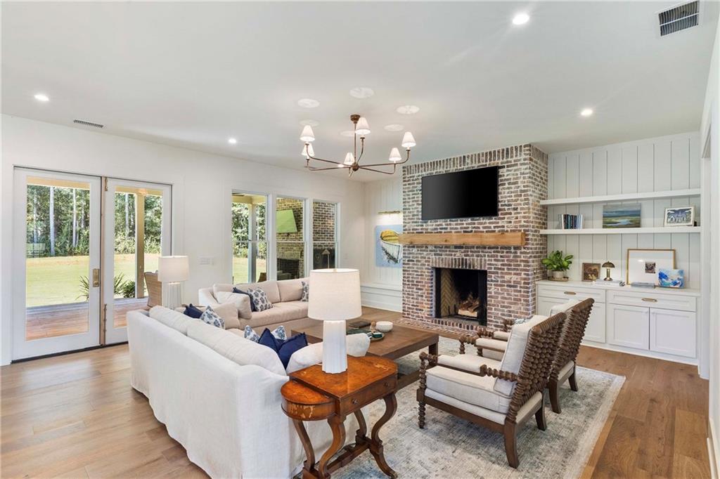 9311 Waterworks Road Chattahoochee Hills, GA 30268 - Photo 16 of 57 a living room with furniture a fireplace and a flat screen tv