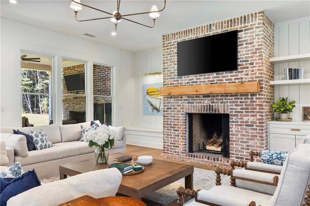 9311 Waterworks Road Chattahoochee Hills, GA 30268 - Photo 17 of 57 a living room with furniture a flat screen tv and a fireplace