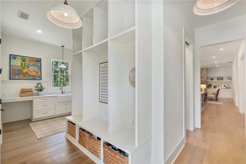 9311 Waterworks Road Chattahoochee Hills, GA 30268 - Photo 35 of 57 a hallway with white cabinets and wooden floor