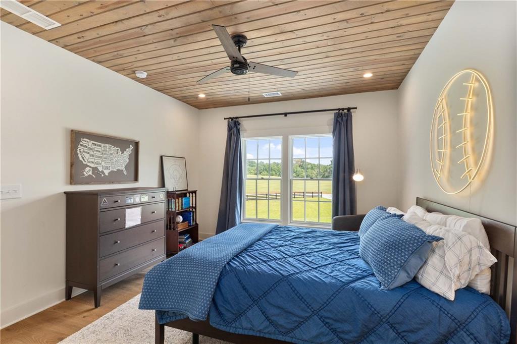 9311 Waterworks Road Chattahoochee Hills, GA 30268 - Photo 47 of 57 a bedroom with a large bed and a chandelier