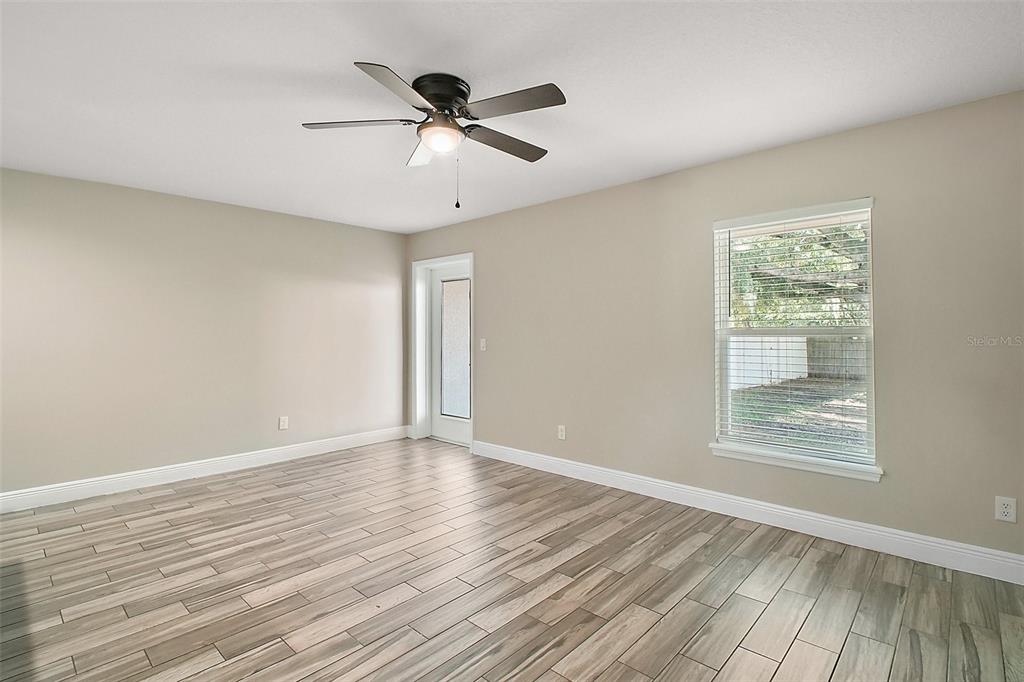 444 Fahnstock Street Eustis, FL 32726 - Photo 3 of 25 a view of an empty room with wooden floor and a window