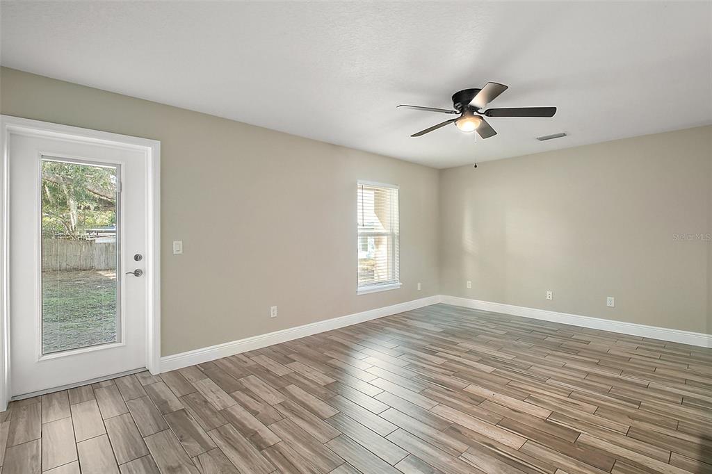 444 Fahnstock Street Eustis, FL 32726 - Photo 4 of 25 a view of empty room with wooden floor and fan