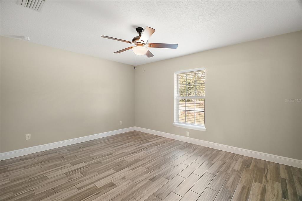 444 Fahnstock Street Eustis, FL 32726 - Photo 8 of 25 wooden floor in an empty room with a window