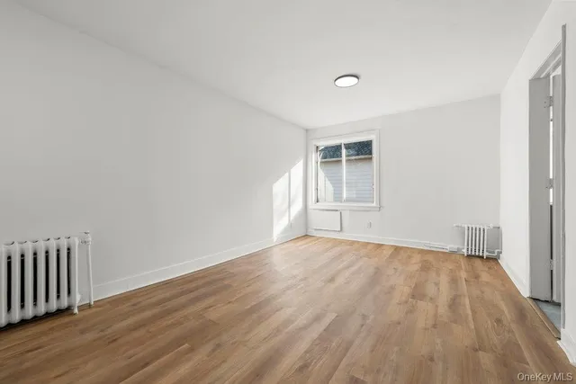 a view of an empty room and wooden floor