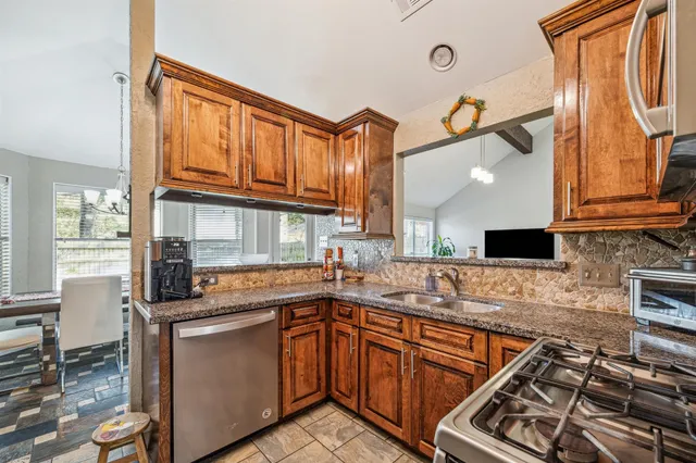 a kitchen with stainless steel appliances granite countertop a sink stove and cabinets