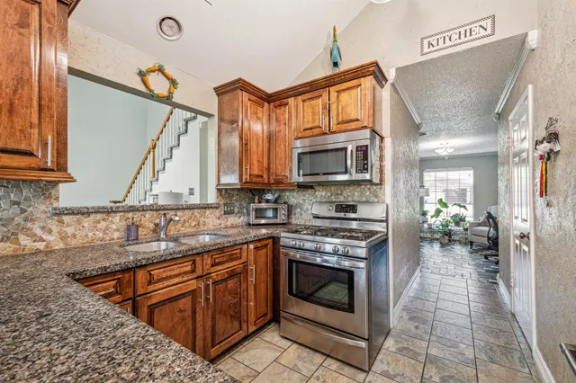 a kitchen with stainless steel appliances granite countertop a stove sink and cabinets