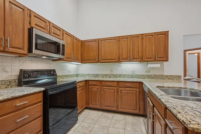 a kitchen with stainless steel appliances granite countertop a sink stove and cabinets