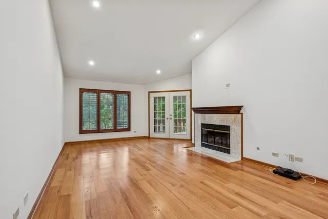 a view of empty room with wooden floor and fireplace