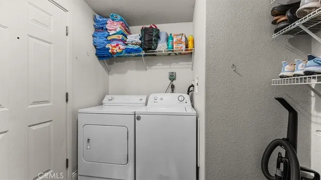 a large bedroom with a large bed a flat tv screen and a chandelier