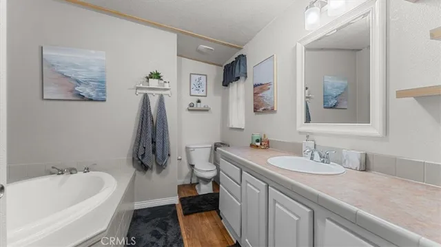 a en suite bathroom with a granite countertop sink and a mirror