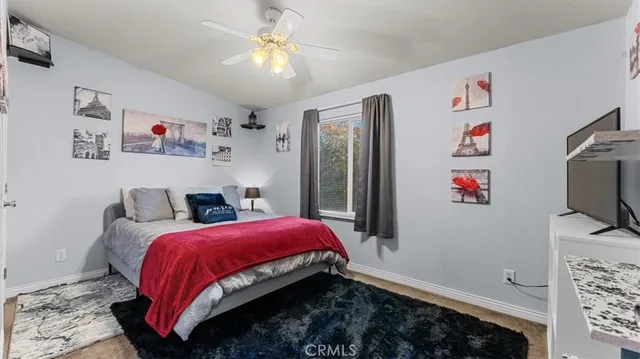 a bedroom with a bed and a flat tv screen on dresser