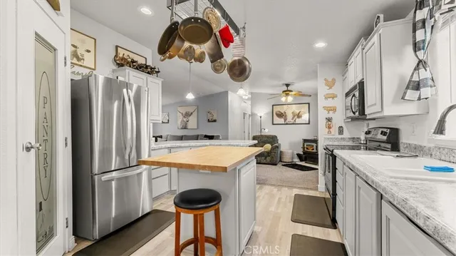 a kitchen with kitchen island granite countertop a sink a stove and cabinets