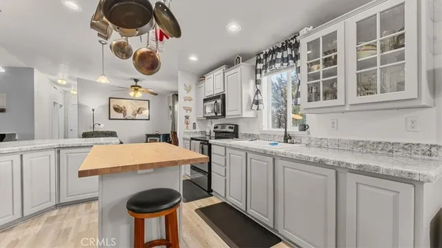 a large kitchen with stainless steel appliances granite countertop a stove refrigerator and a sink