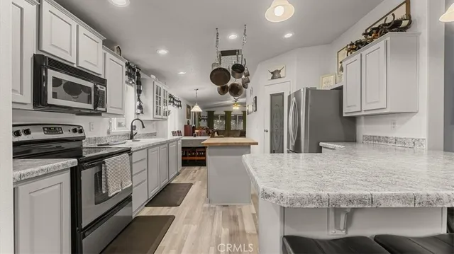 a kitchen with stainless steel appliances granite countertop a sink stove and microwave
