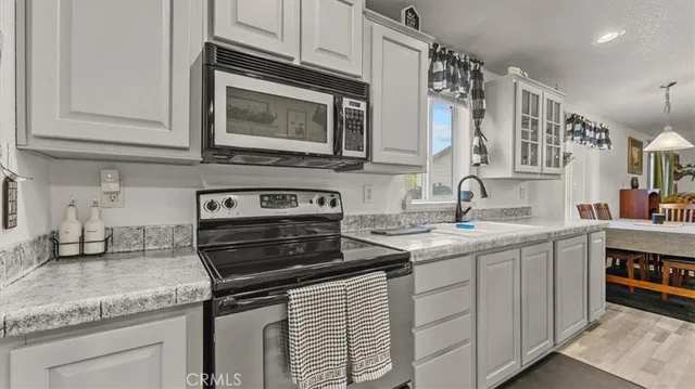 a kitchen that has a refrigerator a sink and white cabinets