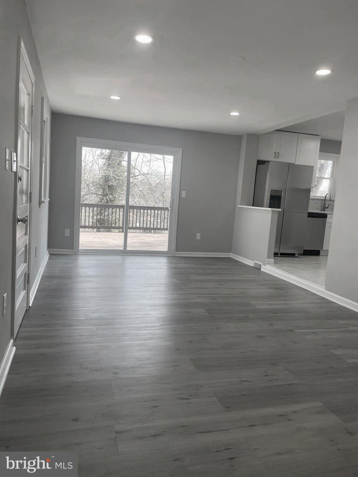 6107 Buckler Road Clinton, MD 20735 - Photo 8 of 45 a view of an empty room with wooden floor and a window