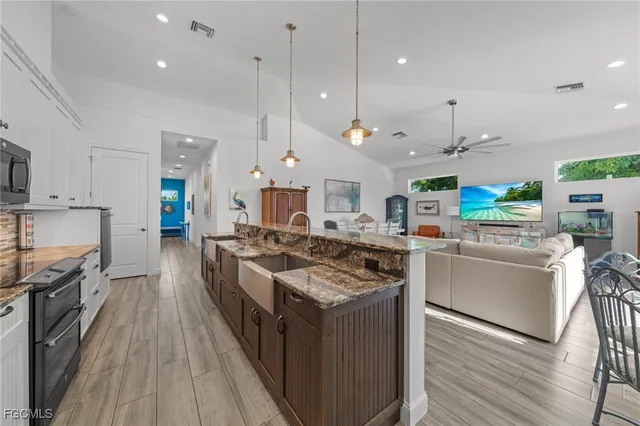 a kitchen with stainless steel appliances granite countertop a stove and a wooden floors