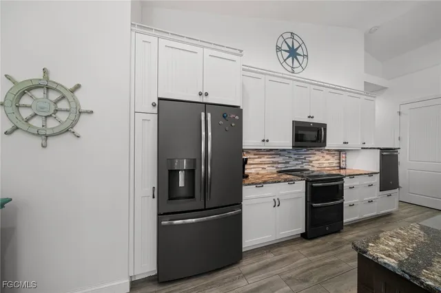 a kitchen with stainless steel appliances granite countertop a refrigerator and a stove top oven