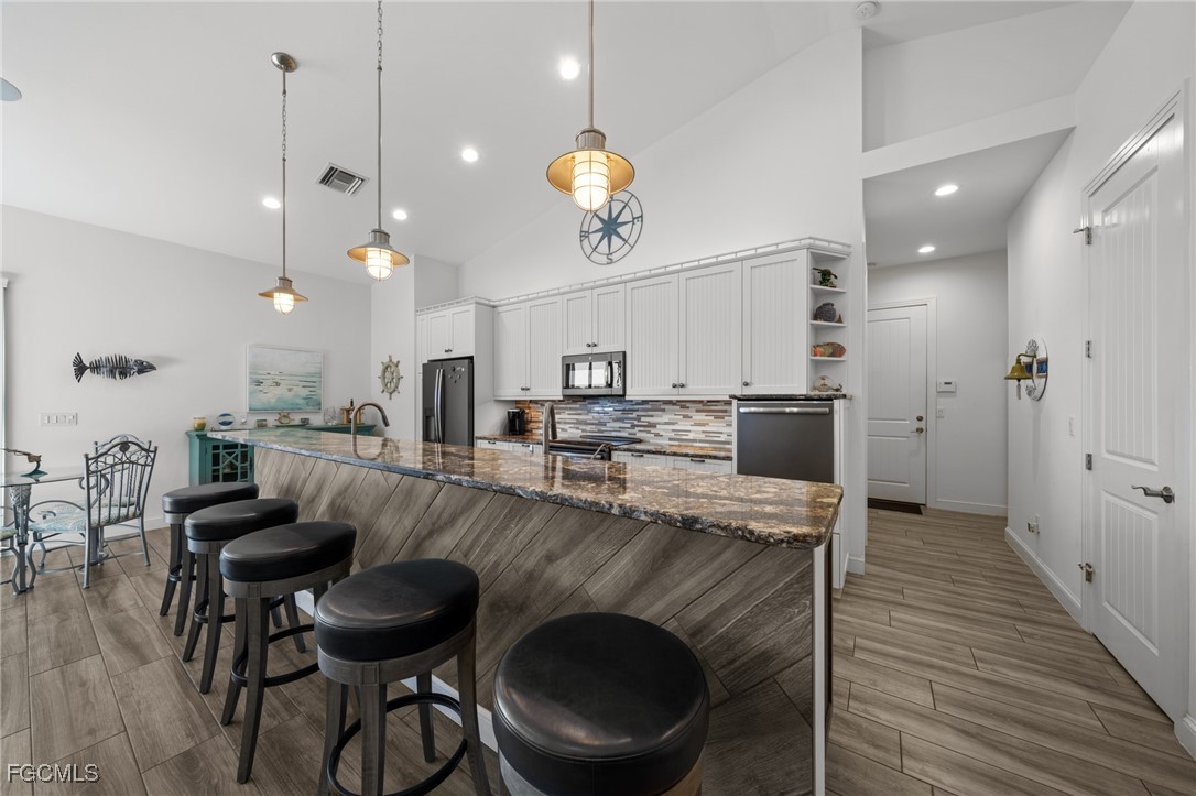 2743 Janet Street Matlacha, FL 33993 - Photo 13 of 45 a kitchen with kitchen island a stove and a wooden floors